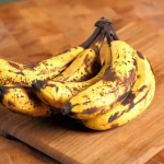 Bananes jaunes suspendues dans une cuisine pour montrer où conserver les bananes correctement
