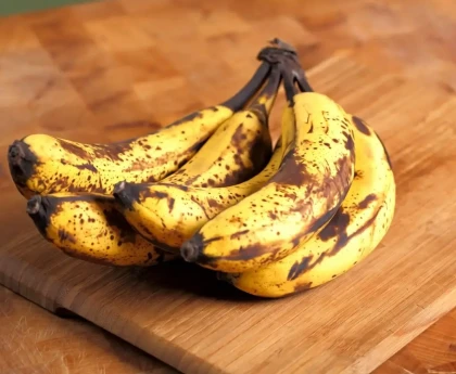 Bananes jaunes suspendues dans une cuisine pour montrer où conserver les bananes correctement