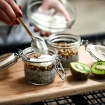 Graines de chia et cuillère en bois avec aliments santé en arrière-plan