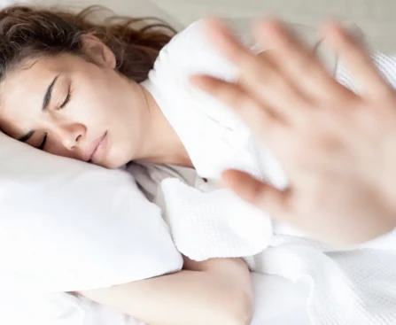 Traversin blanc posé sur un lit avec personne dormant confortablement sur le côté
