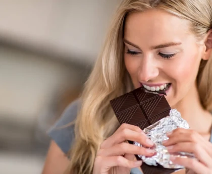 Carrés de chocolat noir sur une assiette avec des amandes, symbolisant le meilleur moment pour en consommer