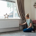 Rideau recouvrant un radiateur sous une fenêtre empêchant la circulation de l'air chaud dans la pièce