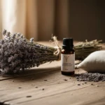 Diffuser la lavande à la maison : diffuseur ultrasonique blanc allumé avec fine vapeur, flacon d'huile essentielle et tiges de lavande séchée sur une étagère en bois