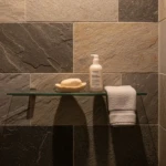 produits de soin peau devant une douche à l'italienne ouverte dans une salle de bains naturelle