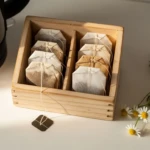 Sachets de thé usagés séchés dans une petite boîte hermétique sur un plan de travail en bois