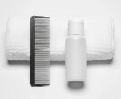 Peigne anti-poux à dents métalliques et flacon de lotion anti-poux sur fond blanc épuré